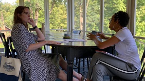 Two people in a session at a table on the Farmhouse porch