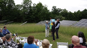 People gathered in chairs as George Brown leads the celebration of the Highlights Foundation solar array.