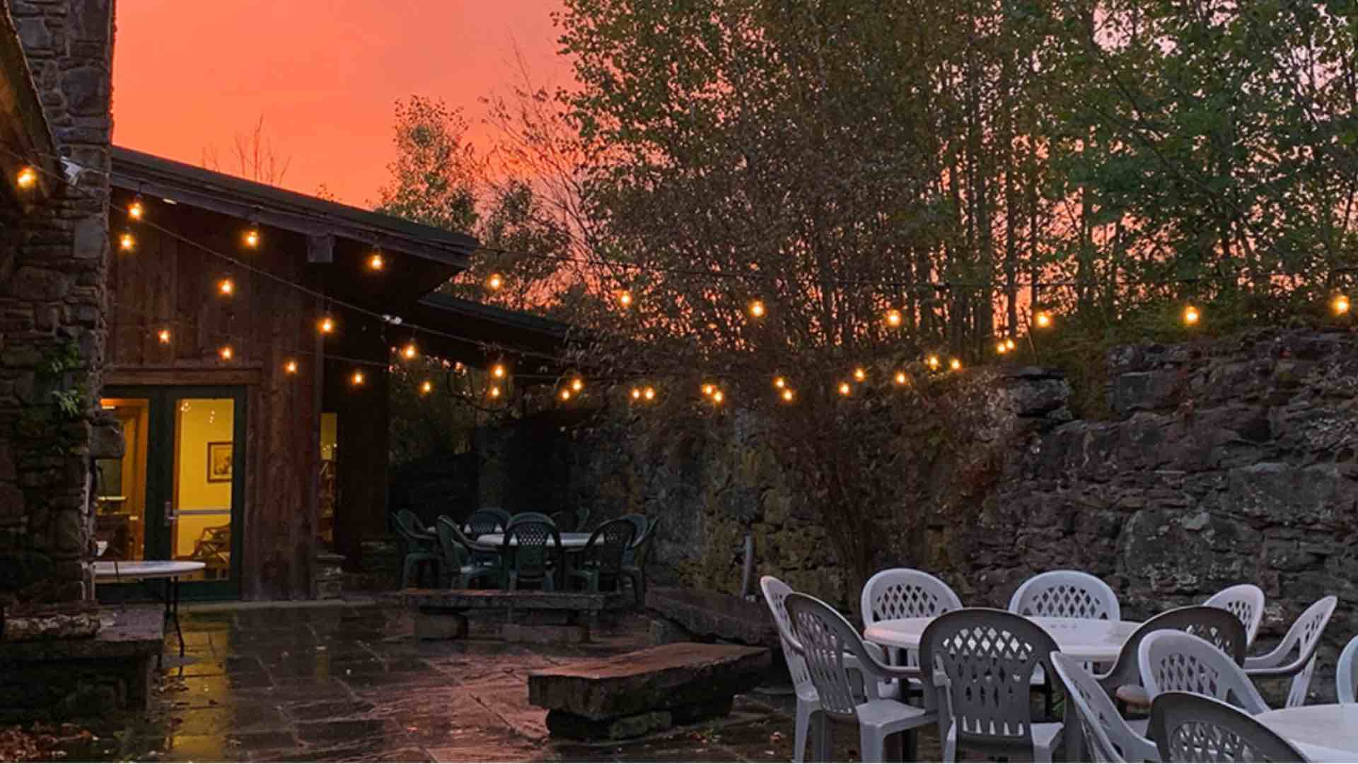 A picture of the Highlights Foundation barn patio at sunset.