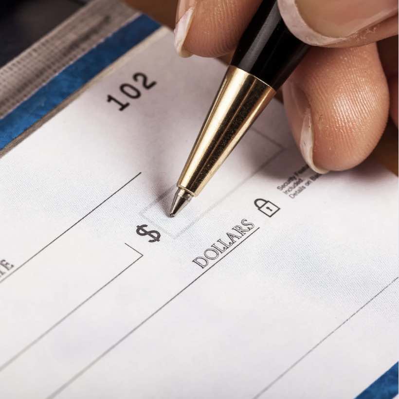 Image of a person writing a check.