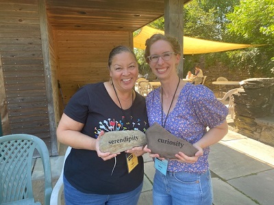 People holding word rocks that say serendipity and curiosity