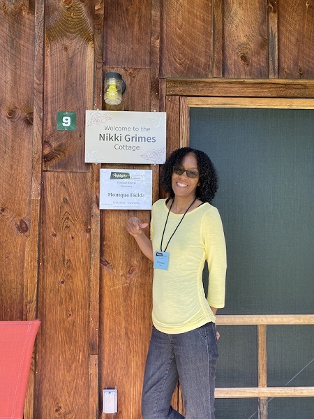 Monique Fields in front of the Nikki Grimes cabin