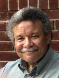 Photo of Paul Ruffins standing in front of a brick wall.