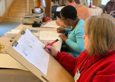 3 attendees working at a table at summer camp