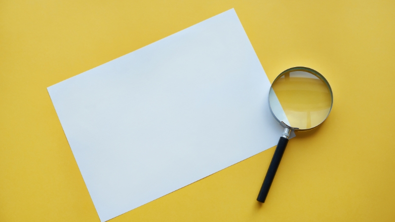 Photo of paper and magnifying glass