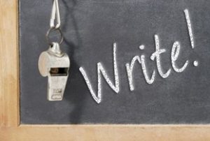 Coach's whistle hanging on a blackboard with the word 