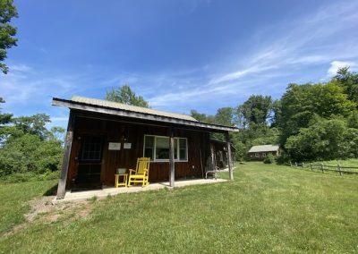 The Exterior of the Floyd Cooper Cabin with a Yellow Rocking Chair