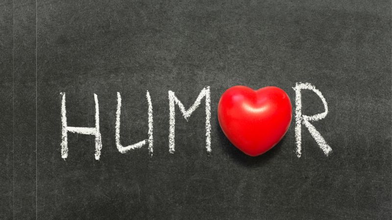 The word humor with a heart on a chalkboard.