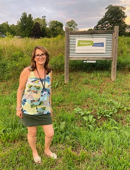 Photo of Doreen Klein Robinson next to the Highlights Foundation sign