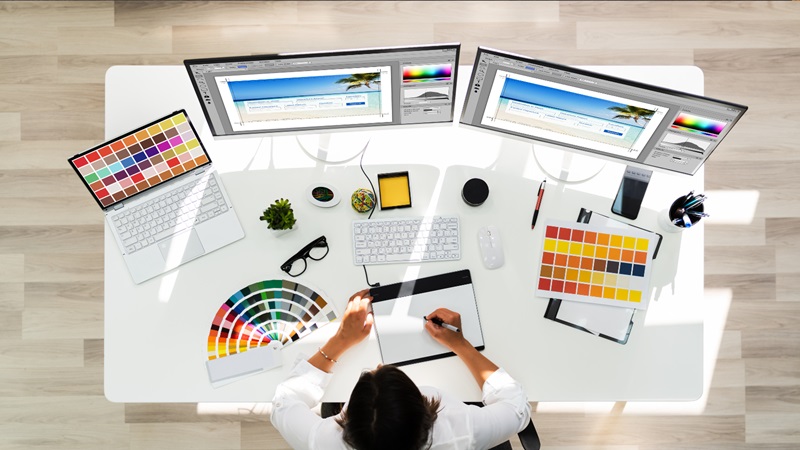 Person at computer desk with art supplies